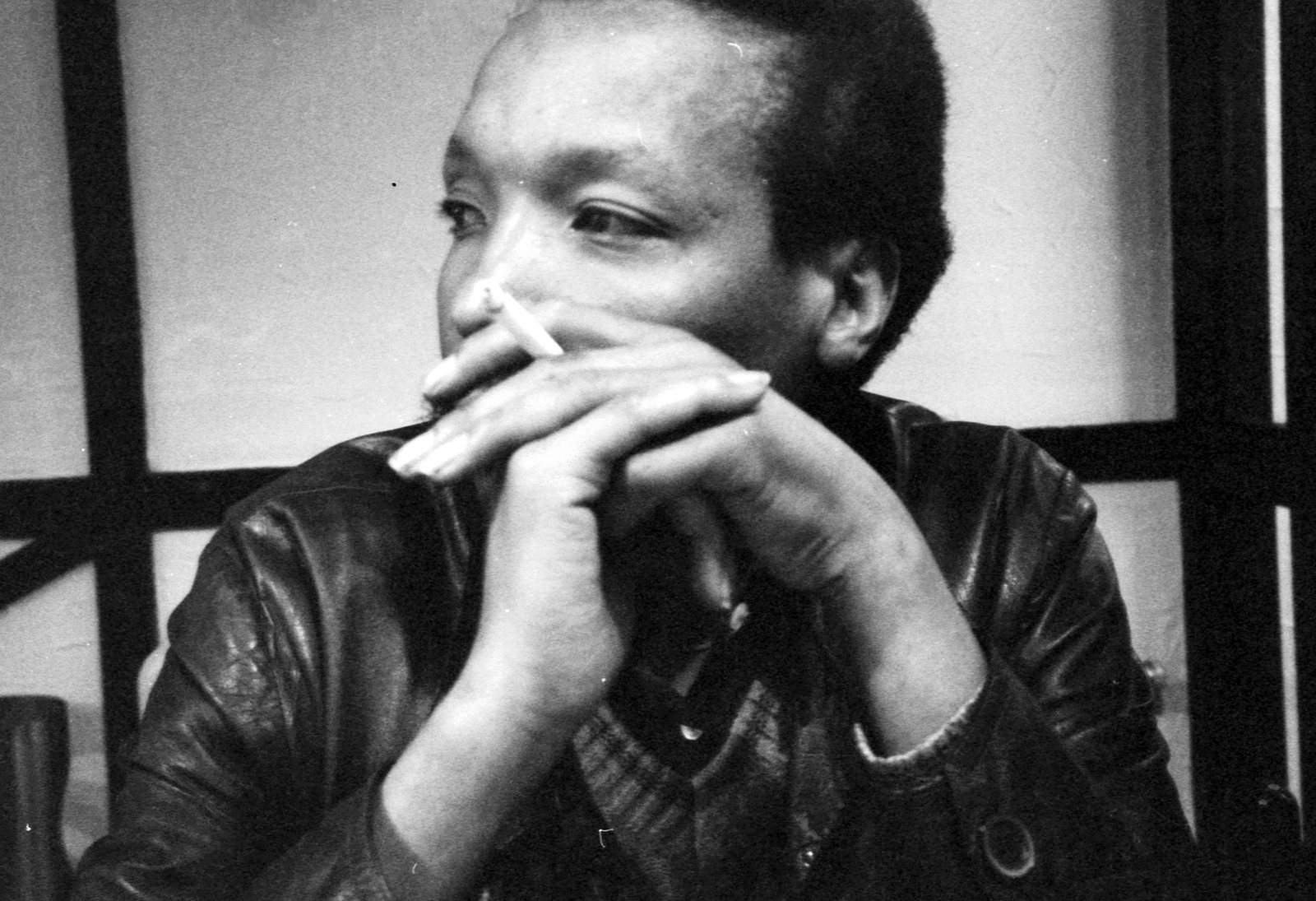 Noël N’Tunda looking aside, a cigarette between his fingers
