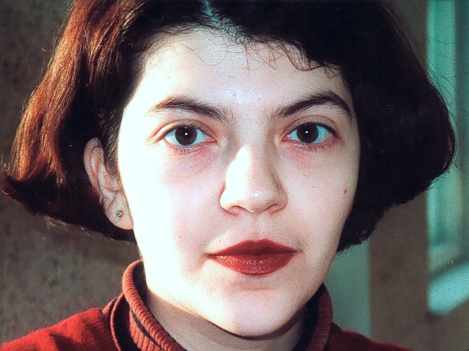 Close portrait of a young woman with a dark red bob and red lipstick
