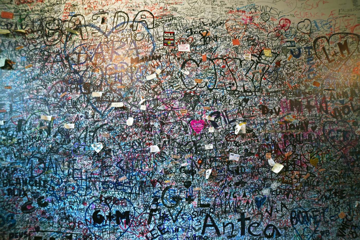 A wall covered with handwritten messages and notes
