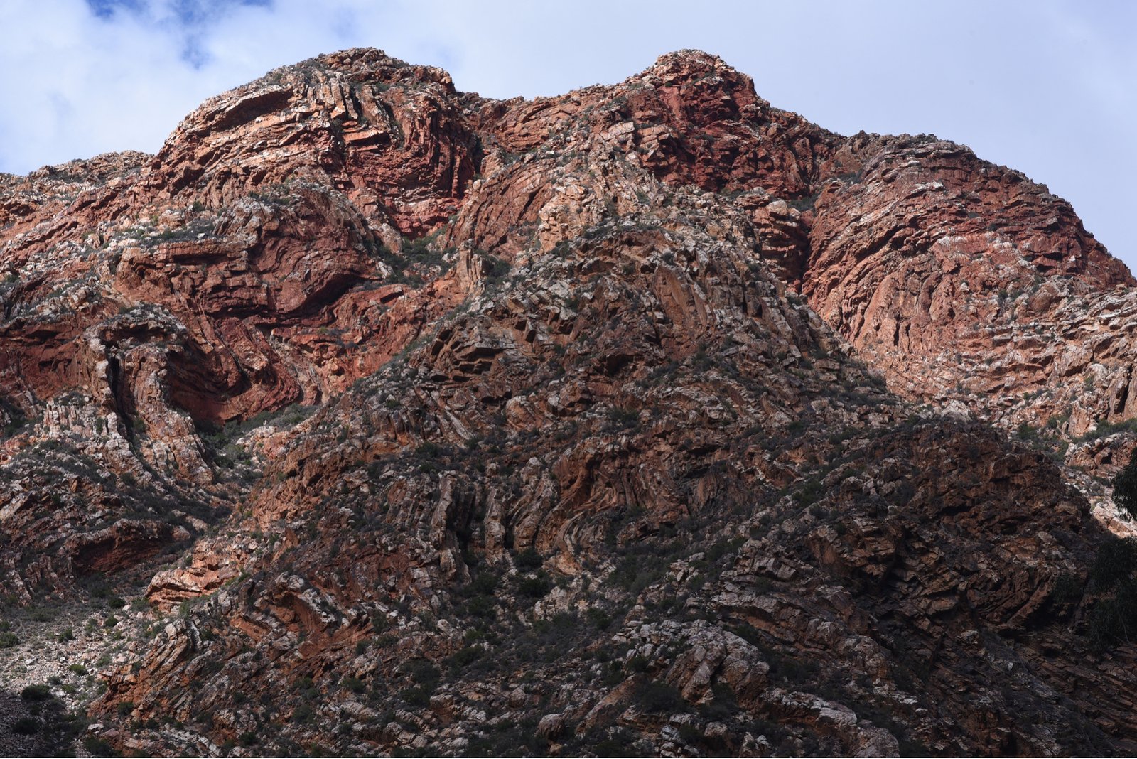 A ridge of folded red rock under a pale sky