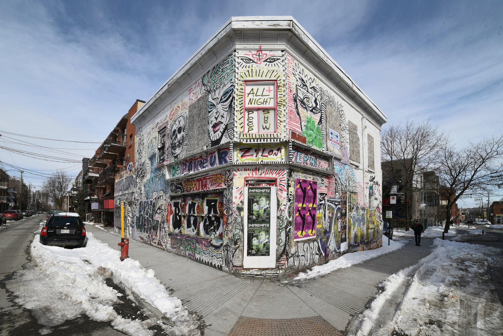 A painted corner building on a street with snow